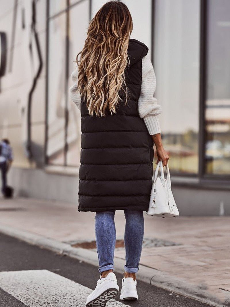Women's black knee-length quilted bodywarmer showcasing the long winter outerwear design and front zipper.