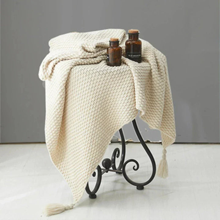Hygge style knitted throw blanket draped across an armchair