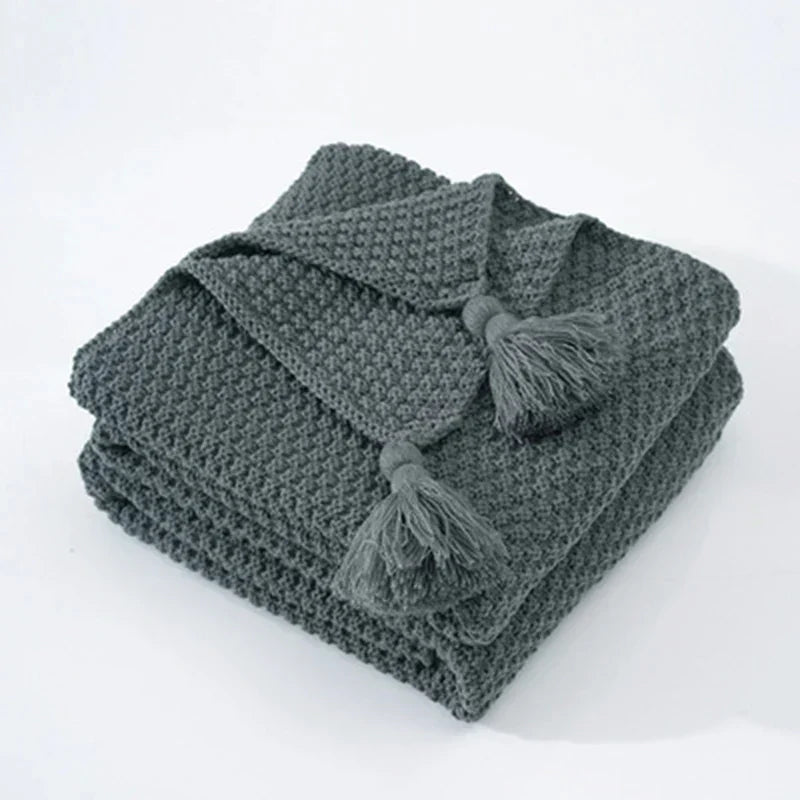 Soft woolen throw blanket folded neatly on a wooden chair