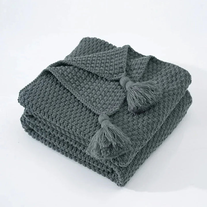 Soft woolen throw blanket folded neatly on a wooden chair