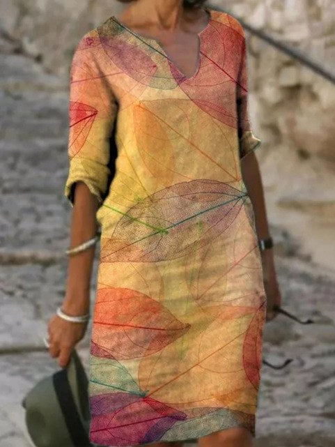 Woman wearing a lightweight yellow summer dress with leaf pattern