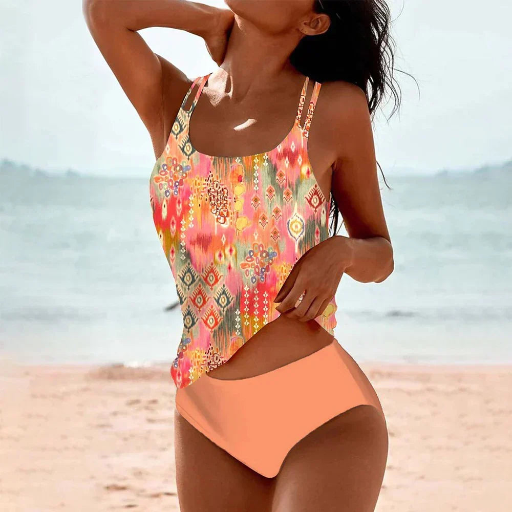 Woman wearing orange printed tankini swimsuit set by the ocean