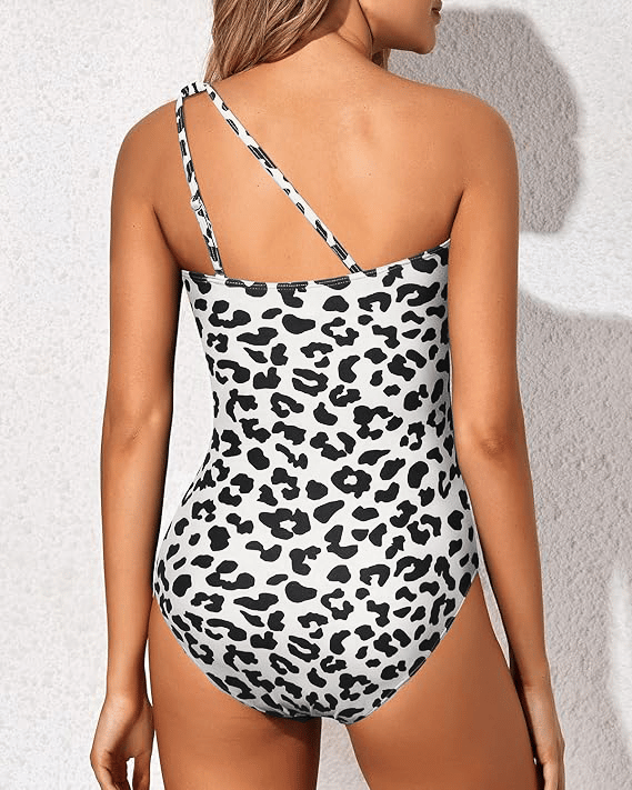 Back view of woman in leopard print one-shoulder swimsuit with adjustable strap detail