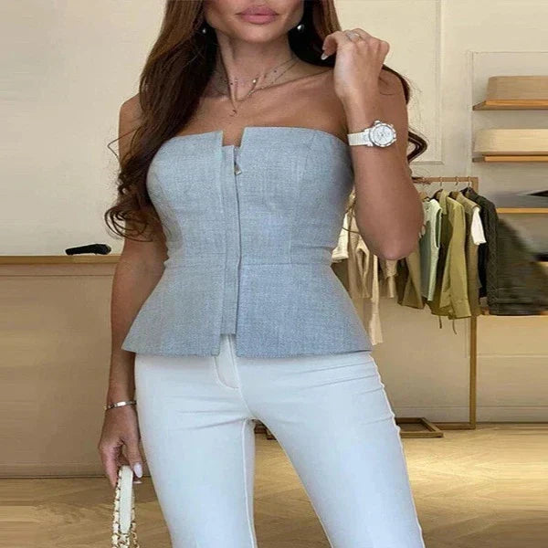 Woman wearing a gray fitted strapless style top with front zipper detail