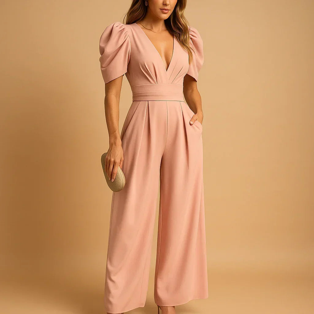 Woman wearing a peach puff-sleeve tailored jumpsuit with a wide-leg silhouette