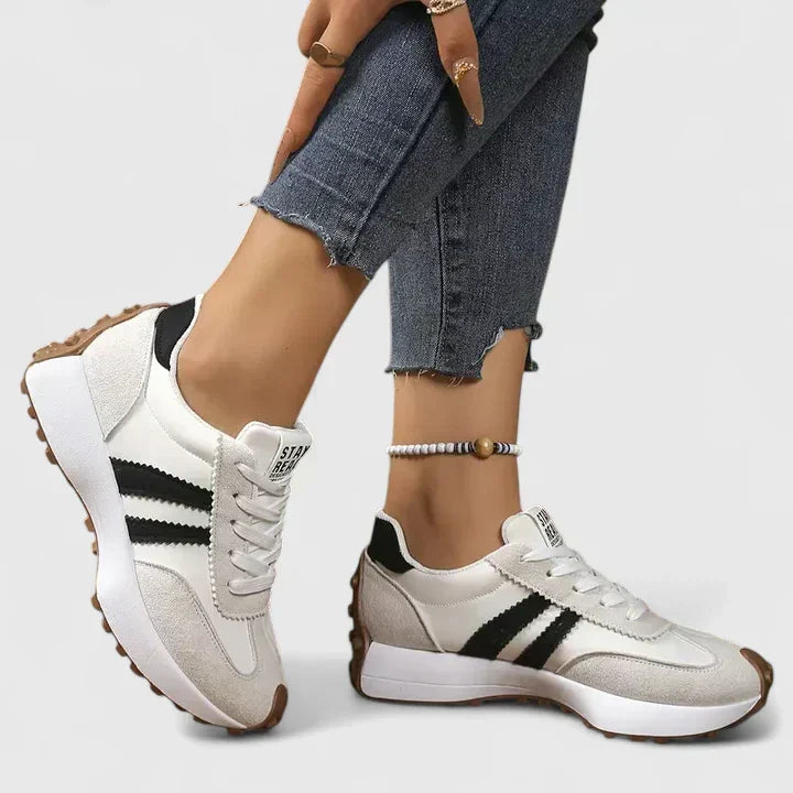 Close-up of white women's orthopedic walking sneakers with black stripes