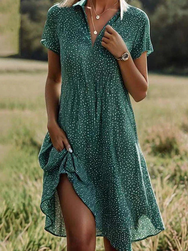 Woman wearing a green short-sleeve midi shirt dress outdoors in a field