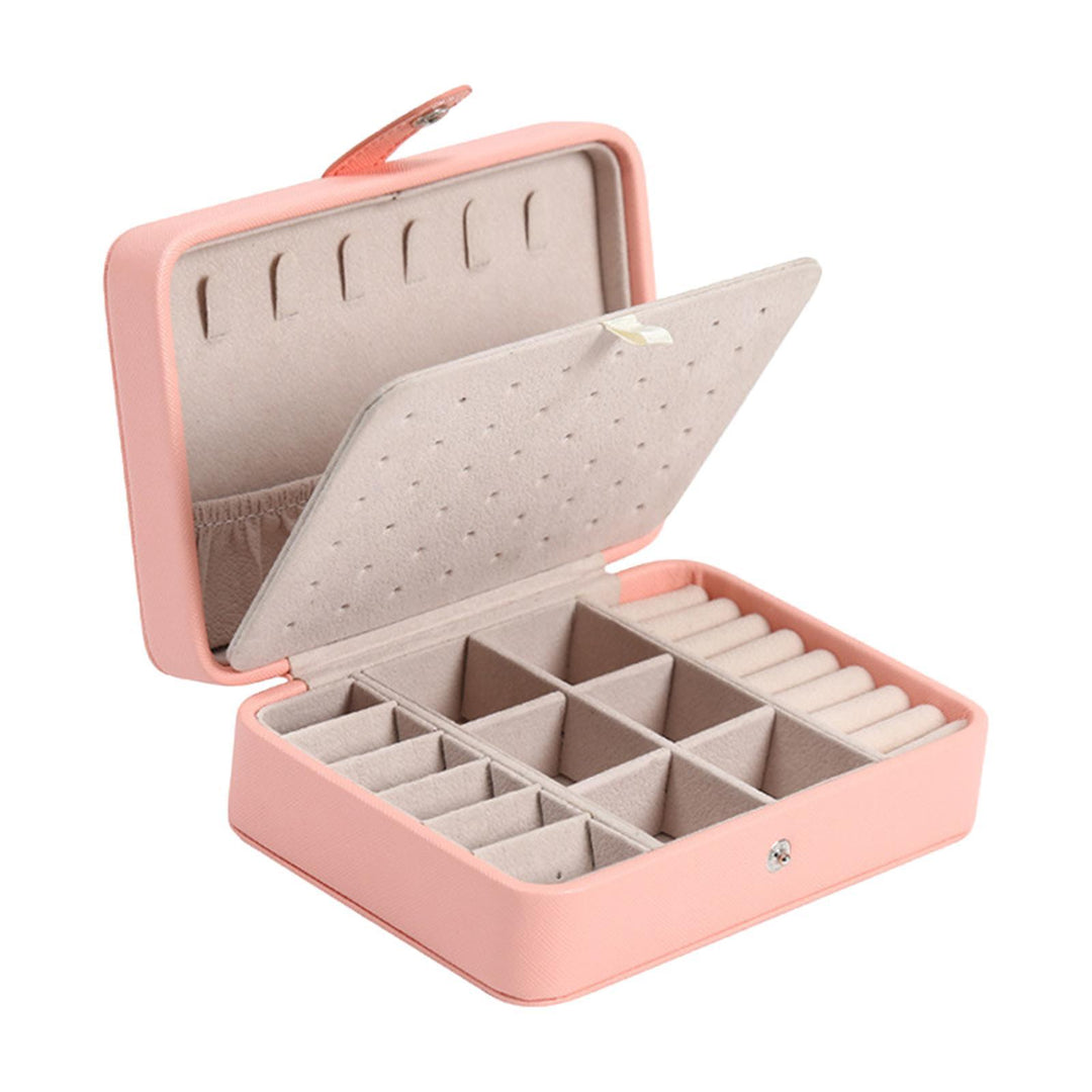 Open pink flip-top jewelry storage box showing ring rolls and compartments