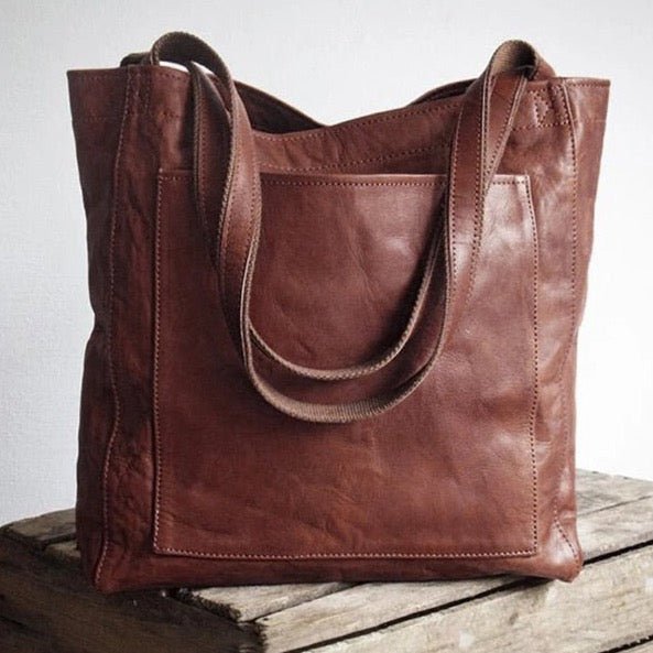 Open interior compartment of womens leather handbag showcasing lining and zipper pockets