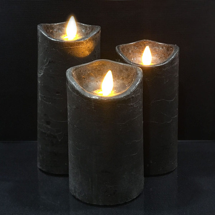 Three dark gray LED pillar candles with realistic 3D flames on a reflective surface