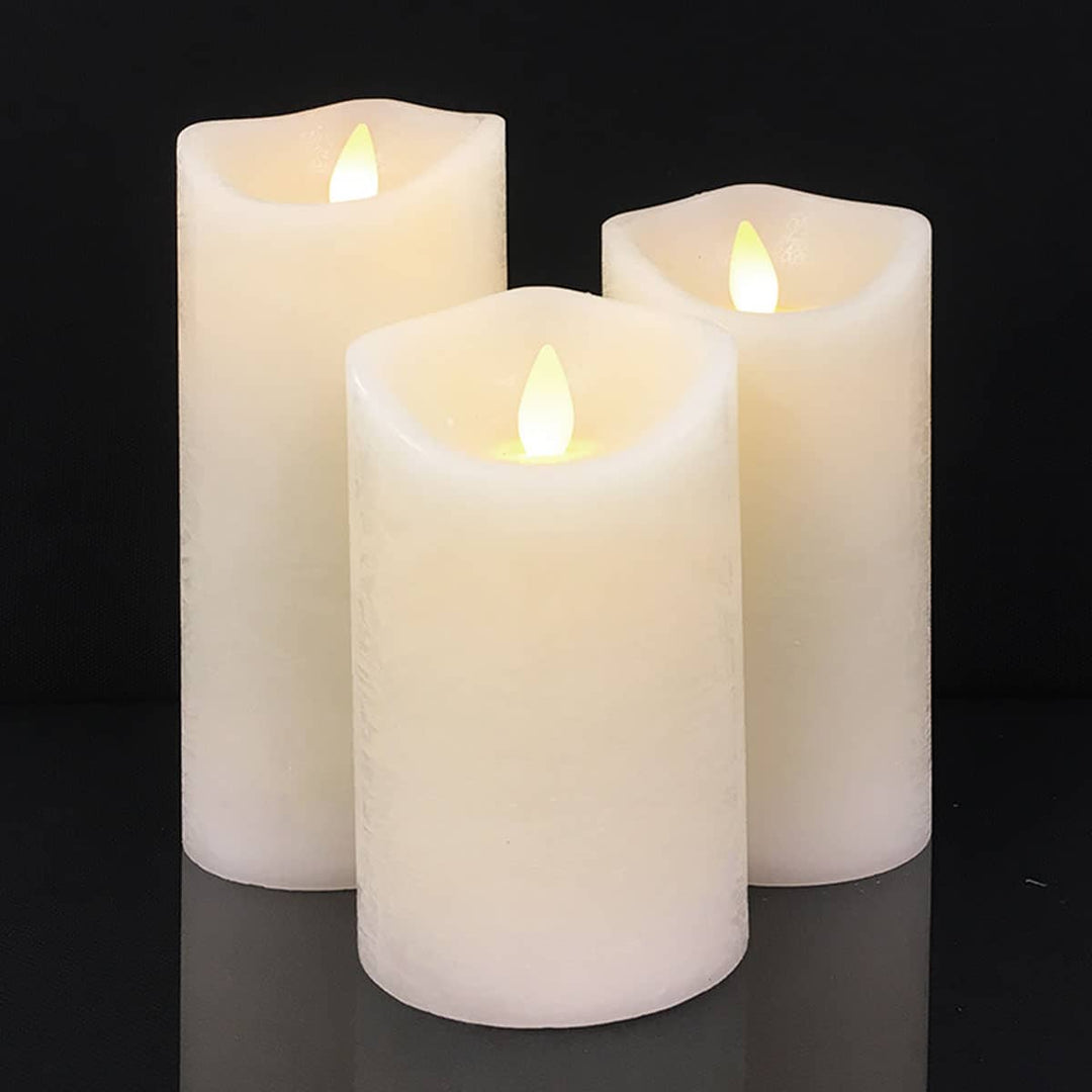 Three cream-colored LED pillar candles emitting a soft, warm glow
