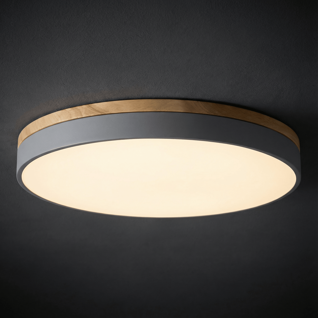 Modern gray LED ceiling lamp illuminating a room with warm ambient light