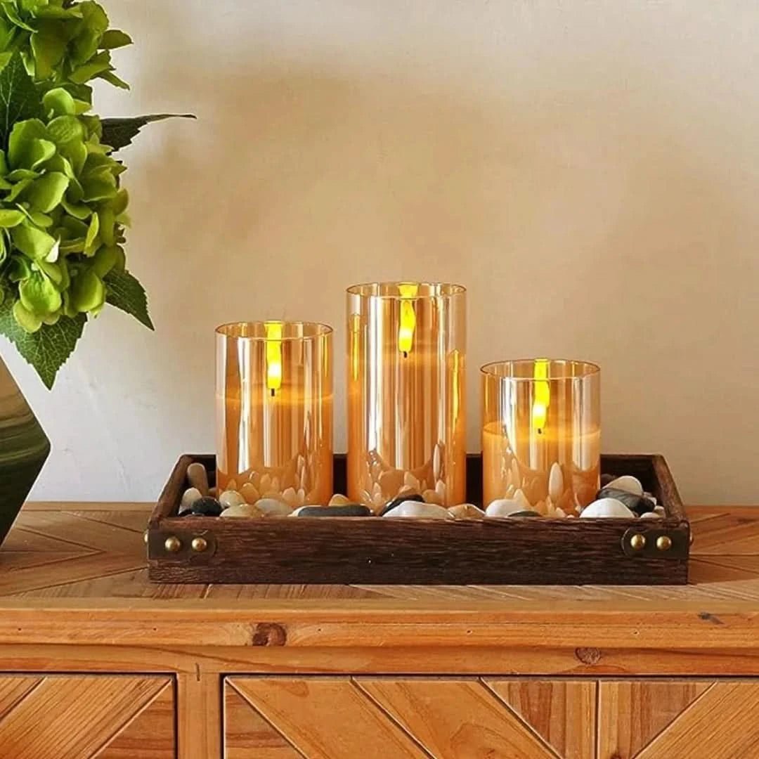 Three amber glass LED flameless candles showcasing a rich glowing ambiance on a tray.