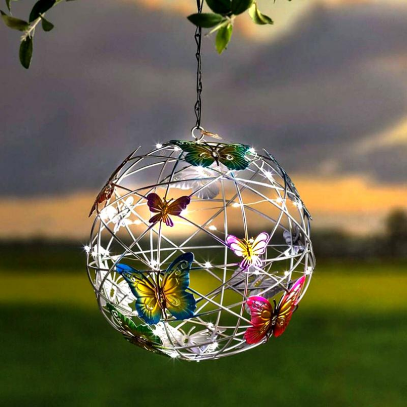 Solar powered LED hanging light with butterfly decorations in a garden