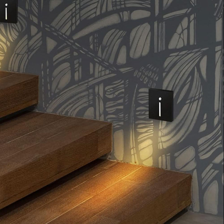 Black LED motion sensor stair light installed on a modern stairway wall