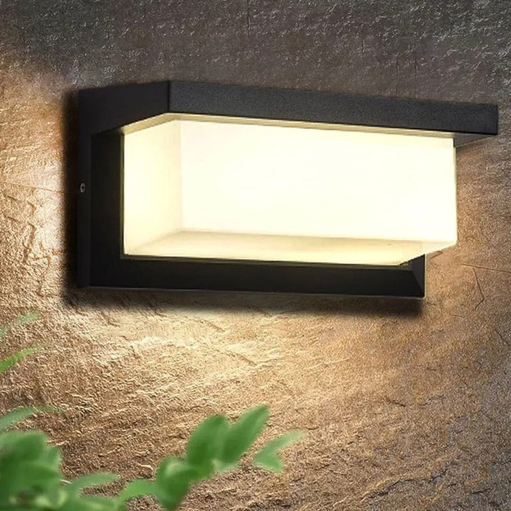 Modern LED outdoor wall light mounted on textured stone wall