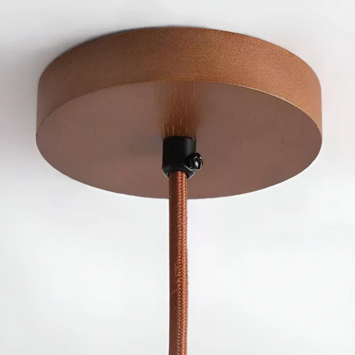 Close-up of the ceiling plate and braided brown suspension cord of the modern pendant lamp.