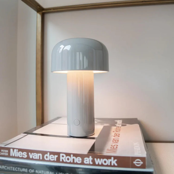 Portable rechargeable LED light fixture in a stylish bedroom setting