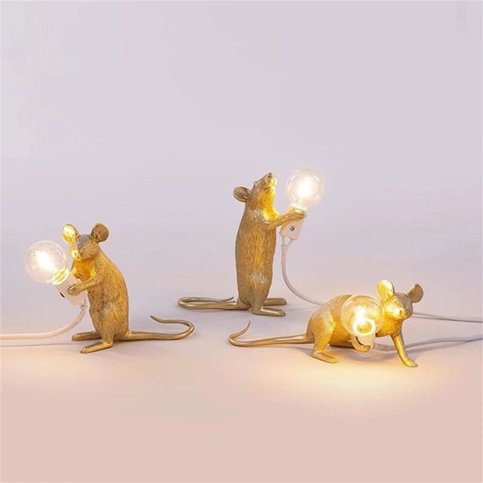 Gold resin mouse LED table lamp sitting upright on a modern bedside table