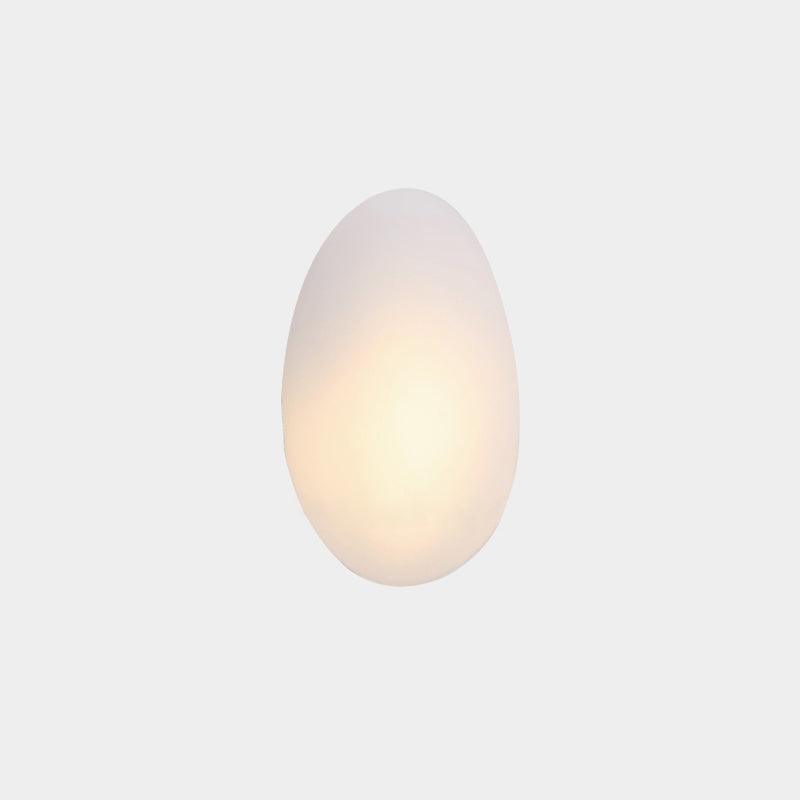 White organic oval LED wall lamp glowing softly against a neutral background