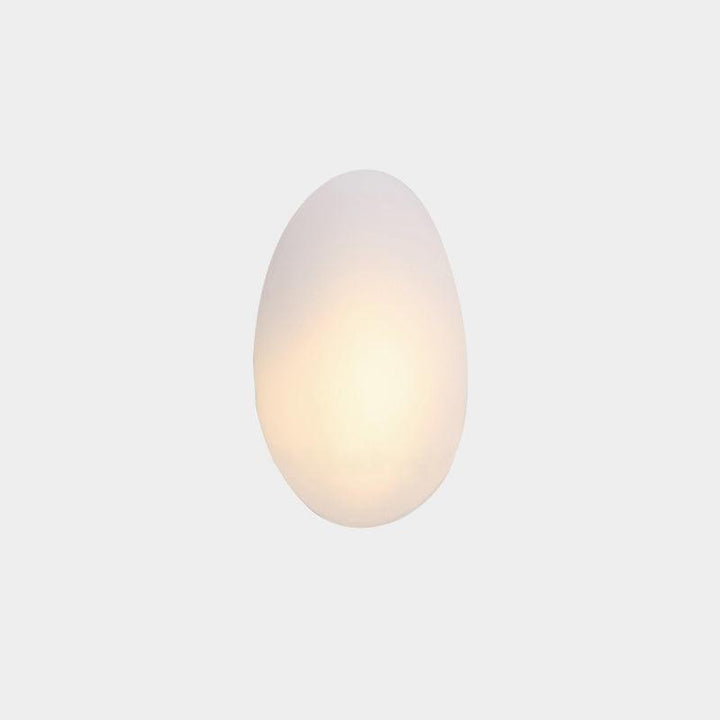 White organic oval LED wall lamp glowing softly against a neutral background