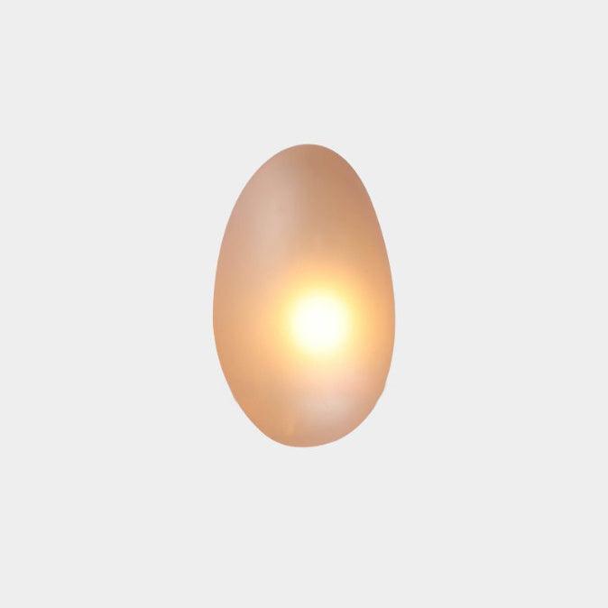 Illuminated oval LED wall lamp highlighting texture of brick wall