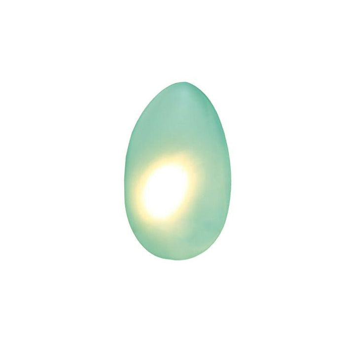 Oval LED wall lamp casting a soft glow on neutral wall