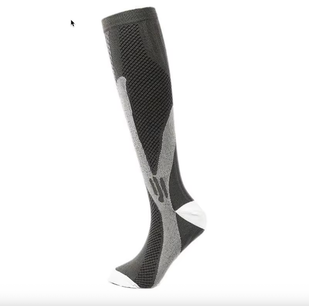 Flat lay of multiple unisex graduated compression socks in various neutral shades.
