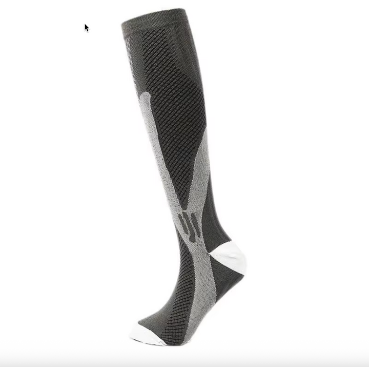 Flat lay of multiple unisex graduated compression socks in various neutral shades.