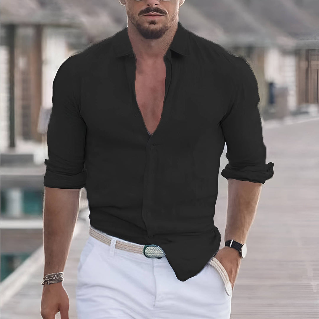 Man wearing a black long sleeve casual button-up shirt with white trousers