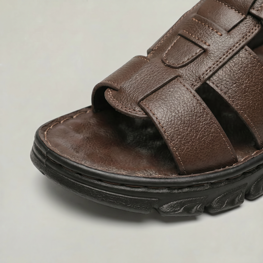 Close-up view of the textured toe area and contrast stitching on brown men's sandals