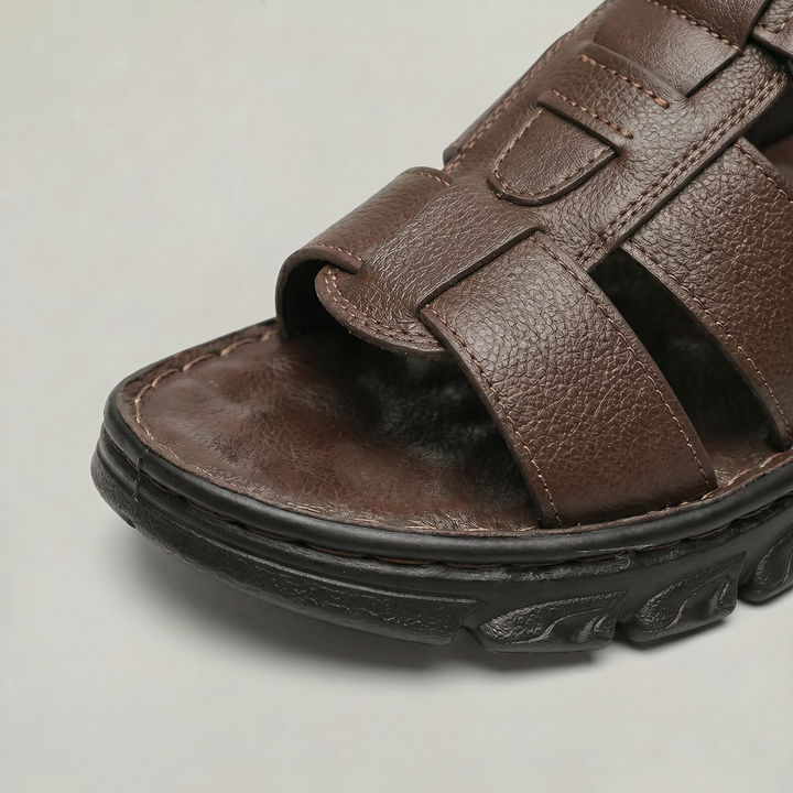 Close-up view of the textured toe area and contrast stitching on brown men's sandals