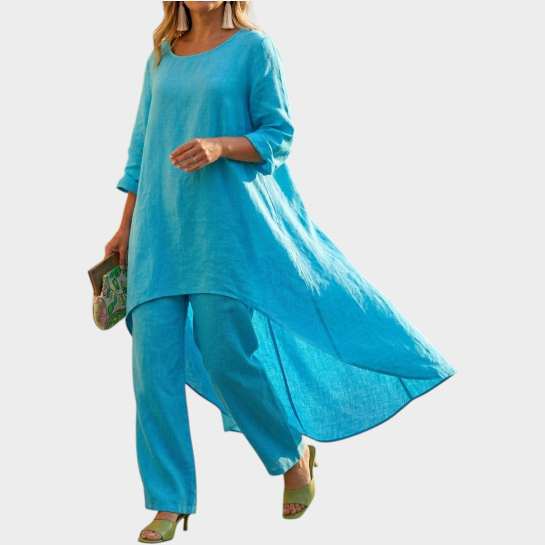 Model wearing sky blue flowy high-low tunic and pants set with matching clutch