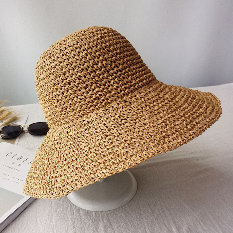 Side angle view of the woven straw-style summer sun hat