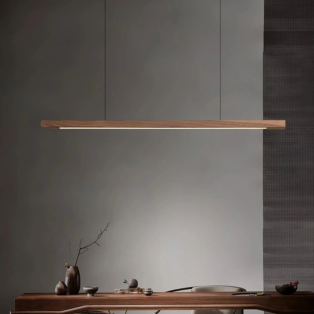 Modern wooden pendant light installed over a wooden dining table in a contemporary dining room