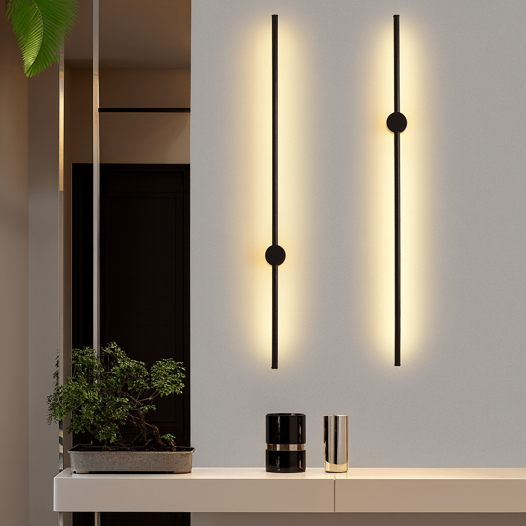 Two black linear LED wall sconces mounted on a white wall above a credenza