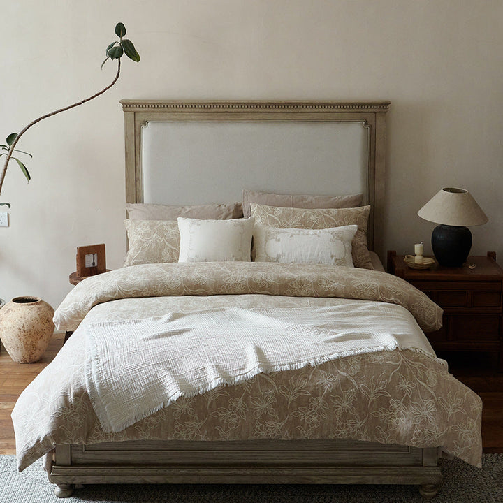 Floral jacquard textured bedding set styled on a wooden bed frame with decorative pillows