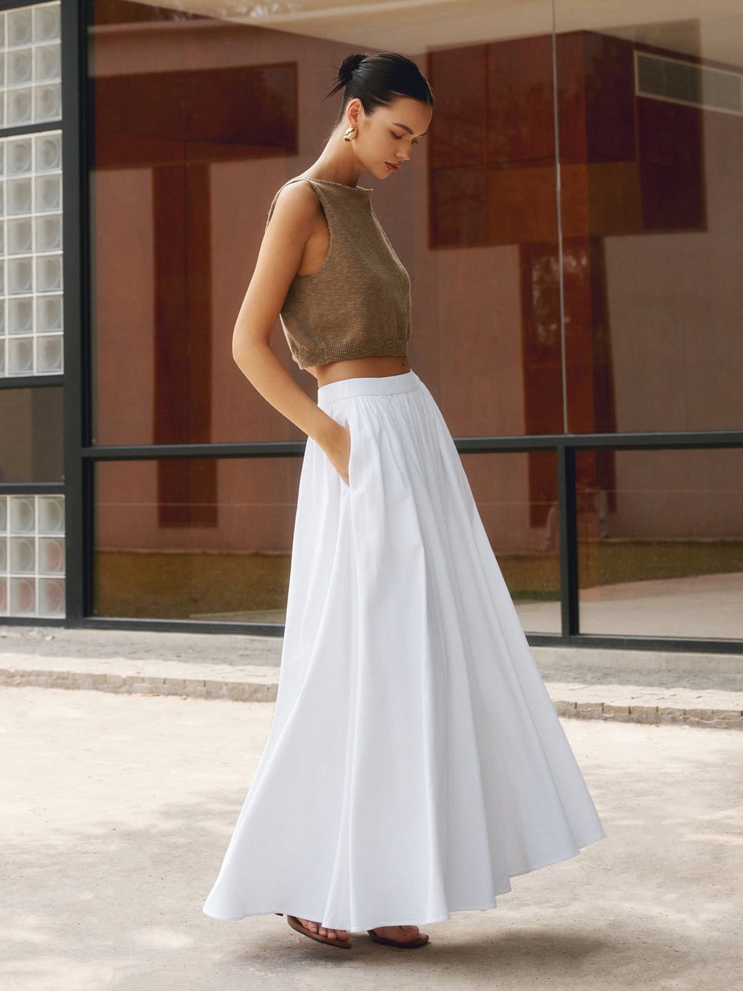 Woman wearing the white Concha flowy midi skirt paired with a knit crop top