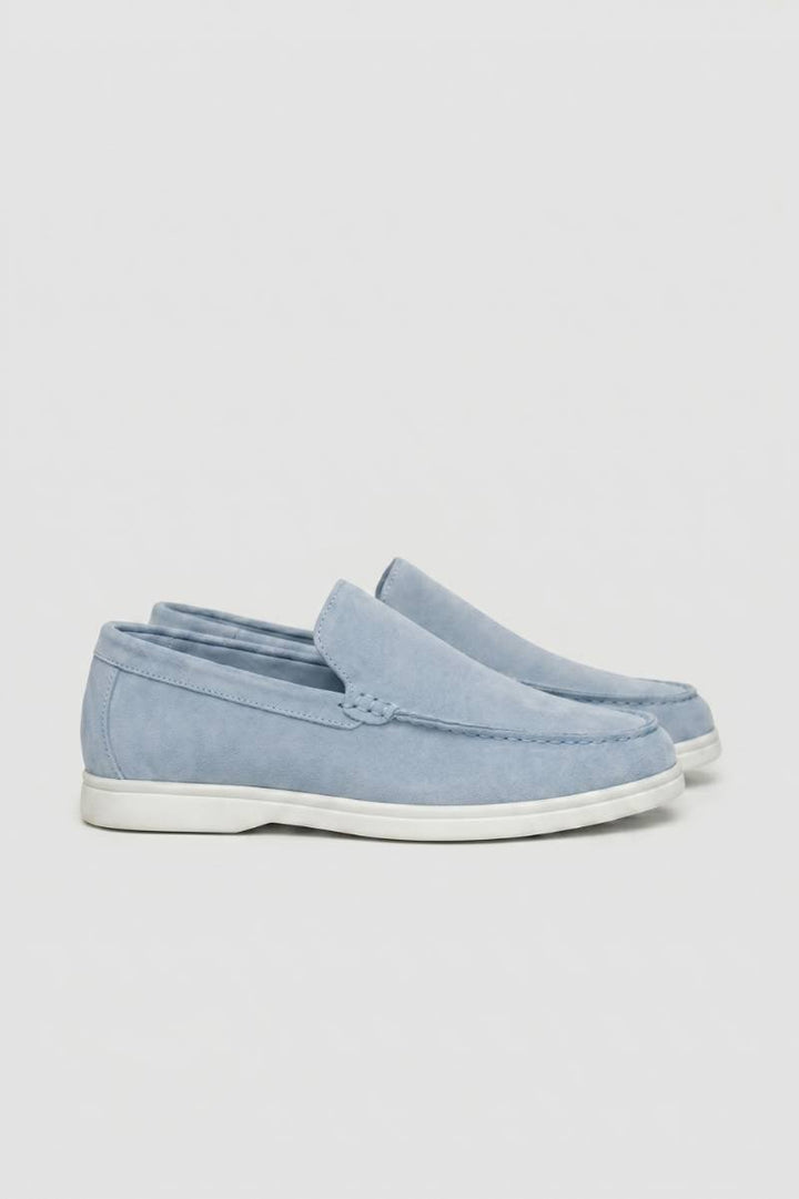 Light blue men's slip-on loafers with white sole viewed from the side