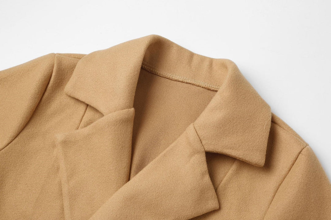 Detail of fabric texture and belt on long wool-look women's outerwear