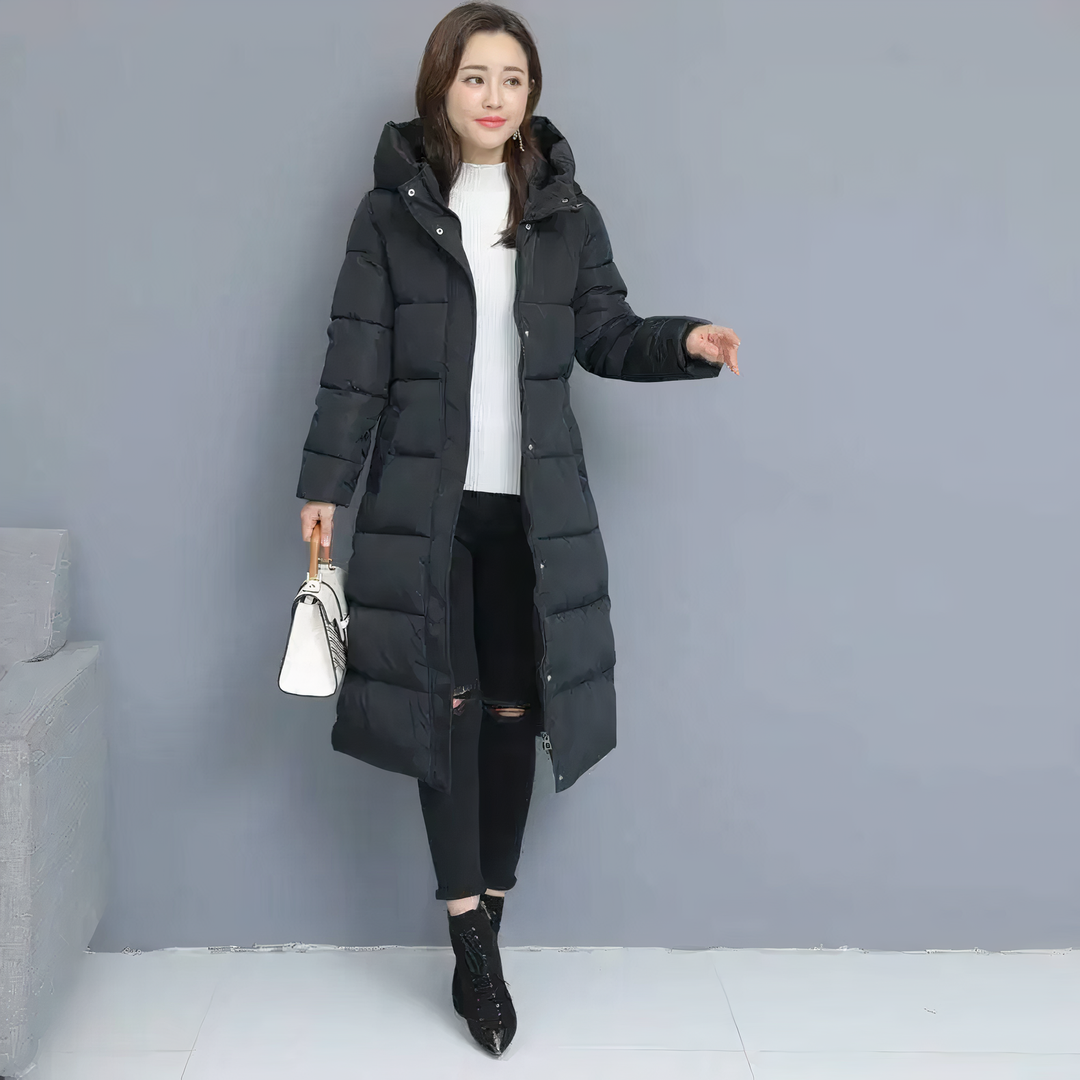 Woman modeling a black long puffer jacket while holding a handbag