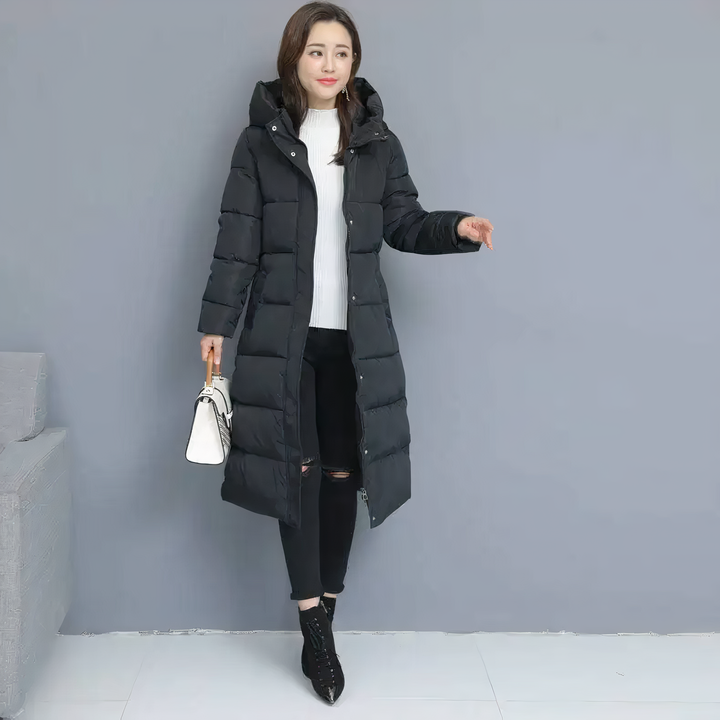 Woman modeling a black long puffer jacket while holding a handbag