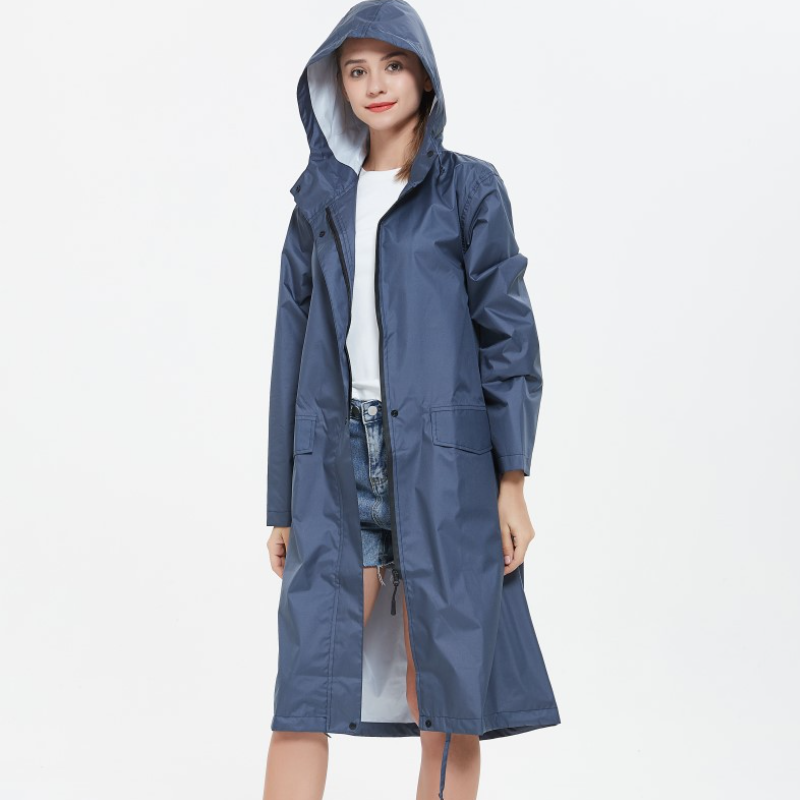 Model showcasing a dark blue long waterproof raincoat with hood and pockets
