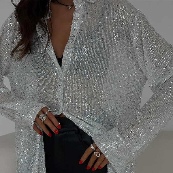 Woman wearing a sparkling white sequin button-down blouse with rings