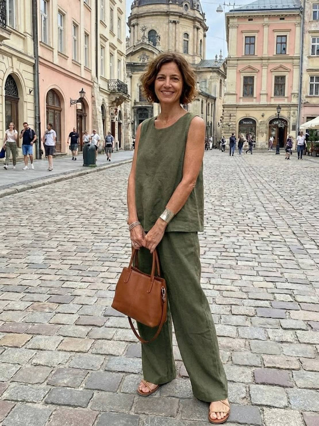 Full-body view of a woman wearing a green matching tank top and trousers set outdoors