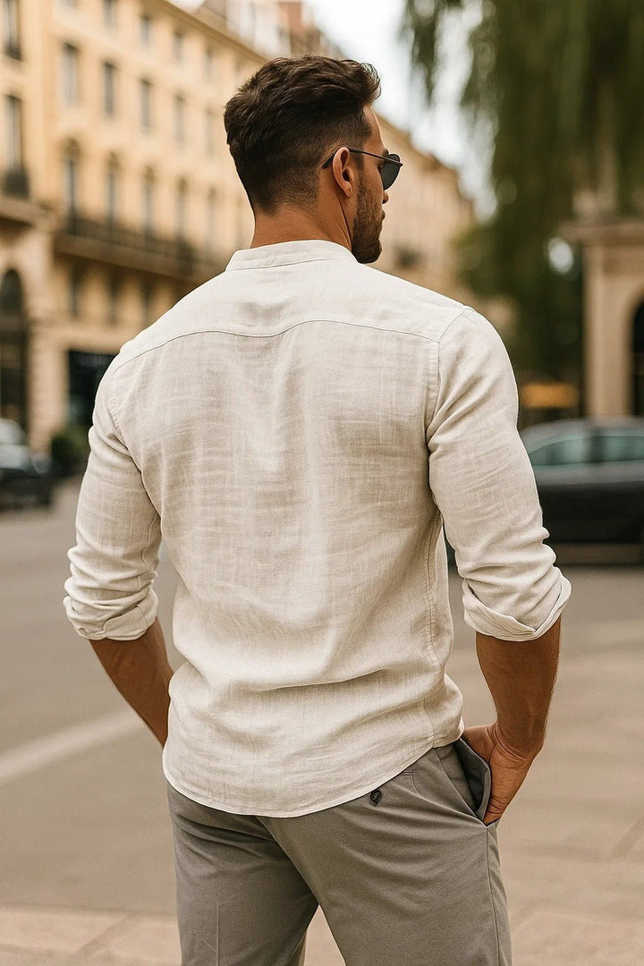 Back view of a man wearing a relaxed fit white long sleeve shirt