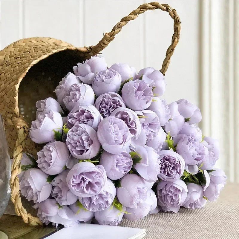 Purple silk peony bouquet resting next to a woven basket