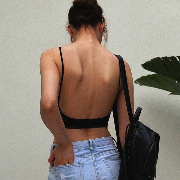 Rear view of a woman wearing a black low back wireless lace bra outdoors