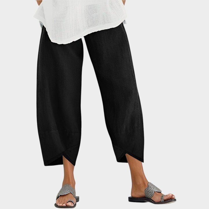 Woman wearing casual black trousers paired with sandals and a white top