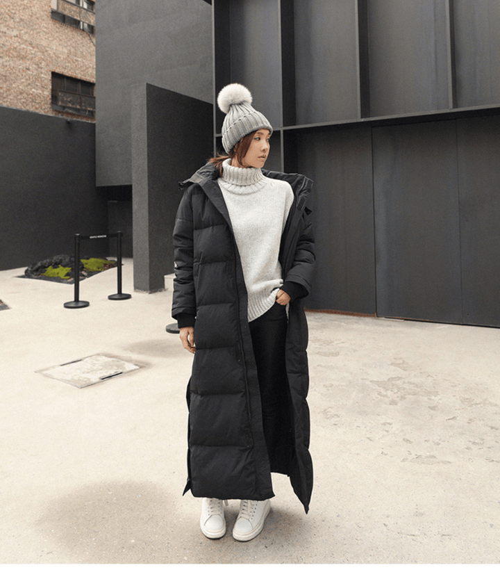 Front view of woman in a black long winter parka with chunky knit sweater